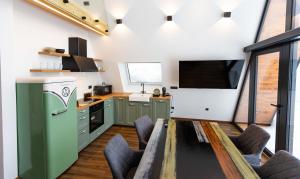 a kitchen with a table and a green refrigerator at Villa Perush in Vuzenica