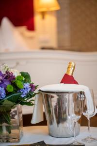 a bottle of champagne in a bucket next to a vase of flowers at Pertschy Palais Hotel in Vienna +17 photos