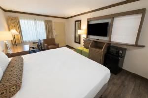 a hotel room with a bed and a flat screen tv at The Dalles Inn in The Dalles