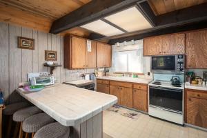 a kitchen with wooden cabinets and a counter top at Mirthwood Den in Tahoma +12 photos