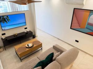a living room with a couch and a flat screen tv at ZELUN Suite Torremolinos Center in Torremolinos