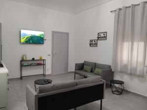 a living room with a couch and a tv on a wall at Carolina's Bedrooms in Trapani