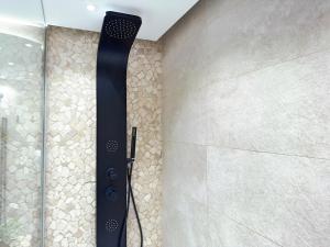 a shower with a black shower head on a wall at ZELUN Suite Torremolinos Center in Torremolinos