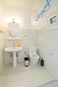 a white bathroom with a toilet and a sink at Alkyon Studios in Myrties +42 photos
