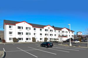 a large white building with a car parked in a parking lot at Inn America - Lewiston in Lewiston