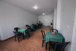 a room with tables and chairs with green tables at Hotel Americano in Americano Brasil