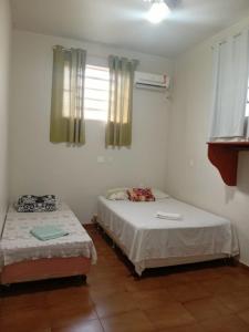 a room with two beds and a window at Hotel Americano in Americano Brasil
