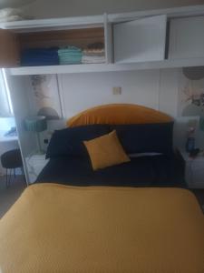 a bedroom with a bed with a yellow pillow on it at 68 Lochview in Stranraer