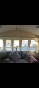 a bed with pillows in front of a window at 68 Lochview in Stranraer