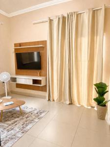 a living room with a television and a curtain at Casa completa, aconchegante com ar condicionado in Montes Claros