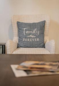 a white chair with a gray pillow that reads family forever at Dolly Varden Cottage in Kings Beach