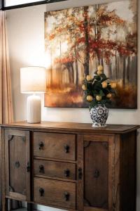 a wooden dresser with a lamp and a painting on the wall at Dolly Varden Cottage in Kings Beach +24 photos