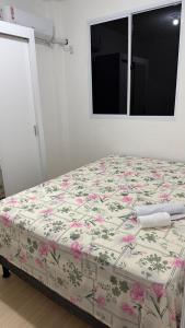 a bedroom with a bed with a floral bedspread at Lazer na linha verde in Camaçari +27 photos