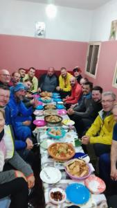 a group of people sitting around a long table of food at Gite ousalem timichi in Timichchi