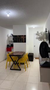 a dining room with a table and yellow chairs at Lazer na linha verde in Camaçari