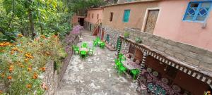 a patio with tables and chairs next to a building at Gite ousalem timichi in Timichchi