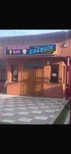 a bar with a sign on the front of a building at Apartamentos Buendia in Buendía