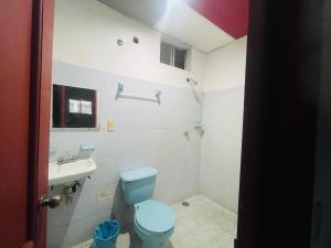 a bathroom with a blue toilet and a sink at Hotel Quinta Don Juan in Tapachula