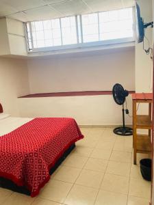 a bedroom with a red bed and a window at Hotel Quinta Don Juan in Tapachula