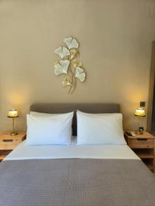 a bed with two pillows and a plant on the wall at Sogno 2 in Parga
