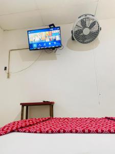 a room with a bed and a fan and a television at Hotel Quinta Don Juan in Tapachula