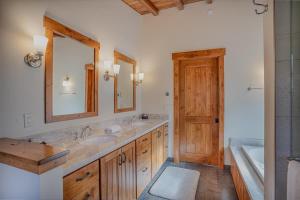 a bathroom with two sinks and a mirror and a tub at Stone Peak Lodge in Tahoe City +48 photos