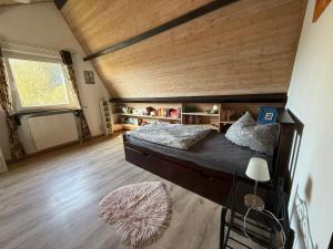 a bedroom with a large bed with a wooden ceiling at Sonnenblick in Edertal