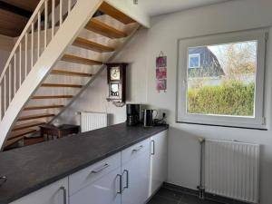 a kitchen with white cabinets and a staircase at Sonnenblick in Edertal