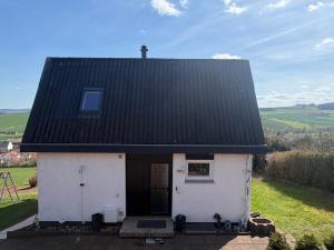 a small white house with a black roof at Sonnenblick in Edertal