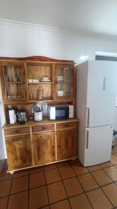 a kitchen with wooden cabinets and a white refrigerator at Casa Pepe La Granda in Trasona