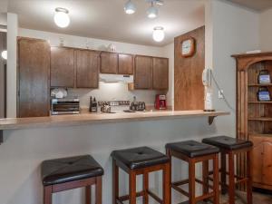 a kitchen with wooden cabinets and black stools at Rooted Resort in Kings Beach +22 photos