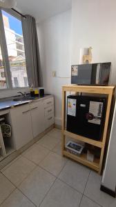 a kitchen with a tv and a counter with a window at Jujuy Centro 2 in San Salvador de Jujuy +3 photos