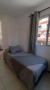 a bed sitting in a room with a window at Jujuy Centro 2 in San Salvador de Jujuy