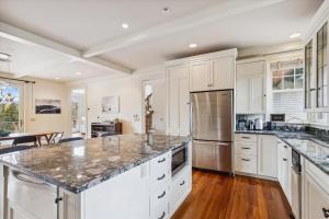 a kitchen with white cabinets and marble counter tops at Weeks Hill Meadows in Stowe