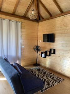 a living room with a blue couch and a television at Fare Teimana Vaianae in Vaianae