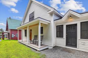 a white house with a black door and a yard at Village with a View in Stowe