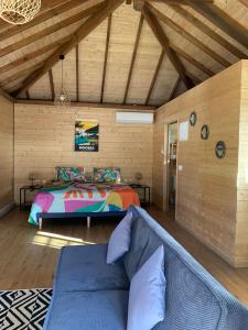 a bedroom with a bed and a couch in a room at Fare Teimana Vaianae in Vaianae