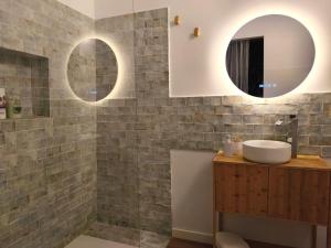 a bathroom with a sink and two mirrors at Bellver bedrooms in Xàtiva