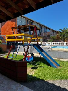 a playground in front of a building at Chalé Maresia Maranduba in Maranduba
