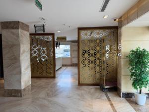a lobby with wooden doors and a potted plant at فندق تمكين-TamkeenHotel- تابع لعلامة كلاديوم- A Cladium brand in Medina