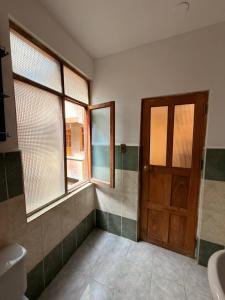 a bathroom with a door and a window and a sink at Central Stay Departamentos I - Camacho in Oruro +21 photos