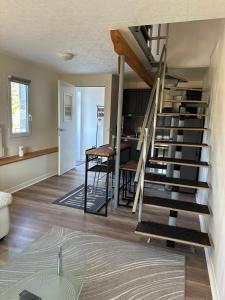 a living room with a spiral staircase and a kitchen at Pure comfort in Entrelacs