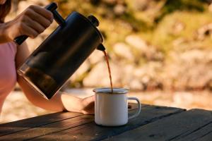 a person pouring coffee into a cup on a table at Paradise Ranch Inn - Ecstatic Tent in Three Rivers +34 photos