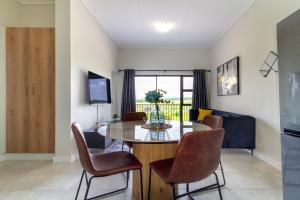 a dining room and living room with a table and chairs at The Greenlee Grove in Sandton