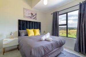 a bedroom with a bed with a large window at The Greenlee Grove in Sandton