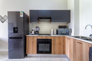 a kitchen with a stainless steel refrigerator and wooden cabinets at The Greenlee Grove in Sandton