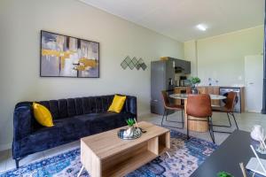 a living room with a blue couch and a table at The Greenlee Grove in Sandton