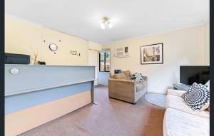 a living room with a couch and a tv at Mount Waverley Townhouses in Mount Waverley