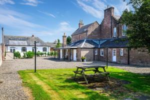 a picnic table in the grass in front of a building at Drumnacree House, Alyth in Alyth