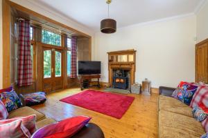 a living room with a couch and a television at Drumnacree House, Alyth in Alyth
